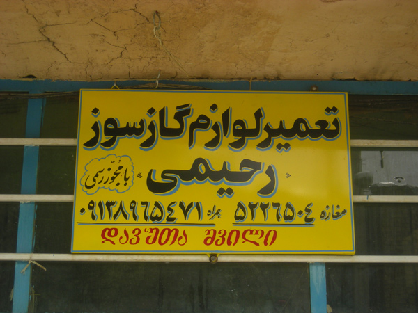 Przykłady gruzińskich nazwisk na tablicach reklamowych lokalnych sklepów