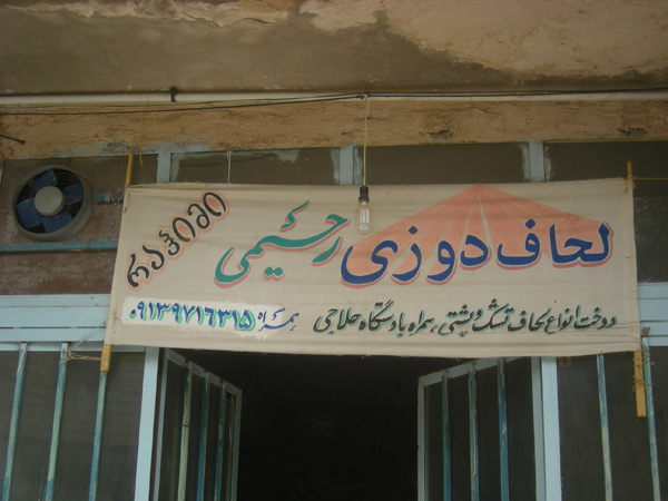 Nazwisko perskie na tablicy reklamowej lokalnego sklepu